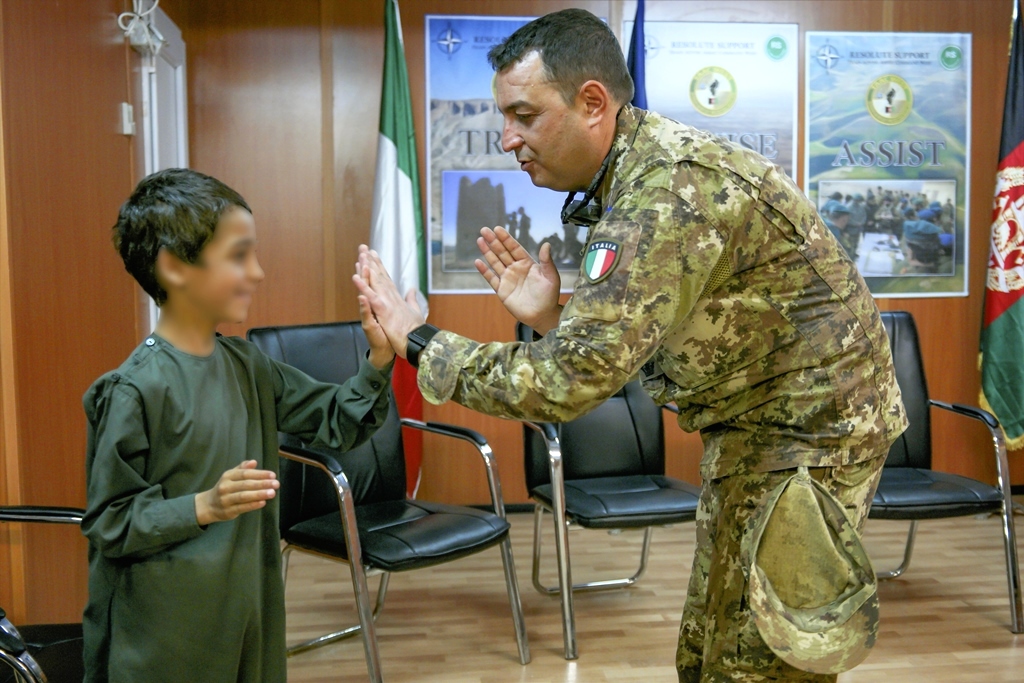 q/militare italiano gioca con un bambino Afghano